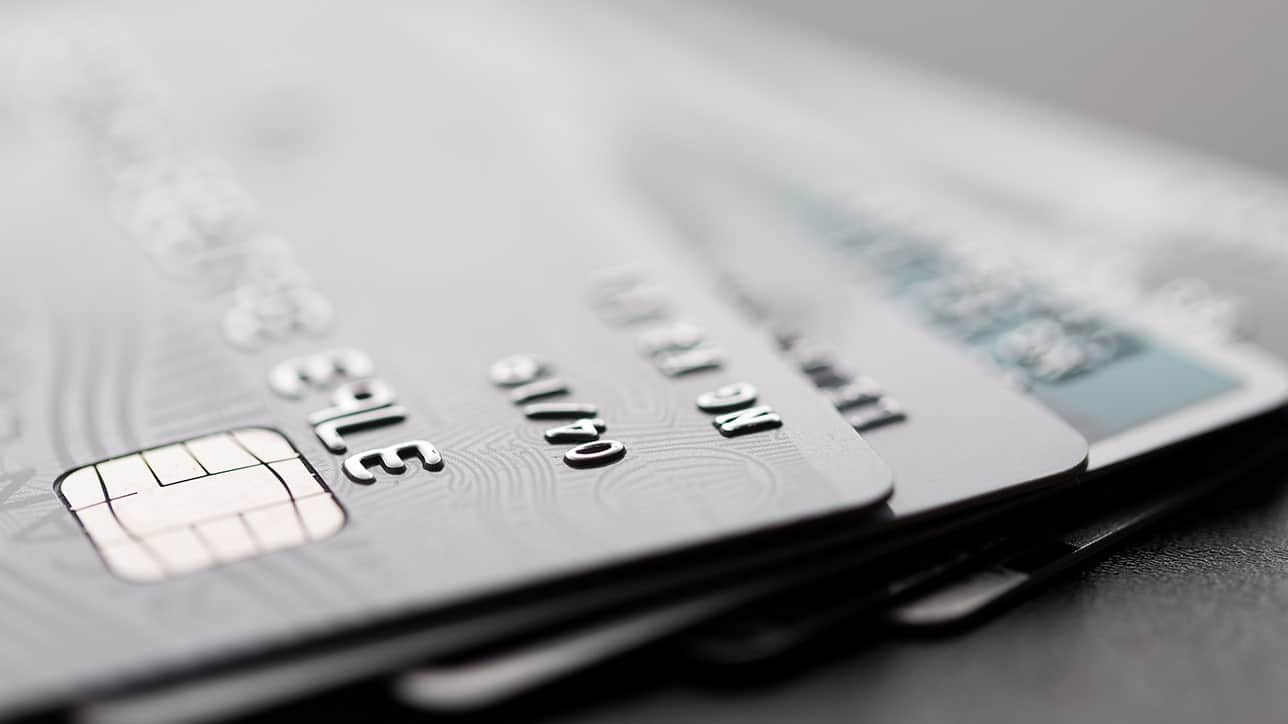 Zdjęcie przedstawia kilka kart kredytowych ułożonych w stosie, z widocznymi chipami i detalami na powierzchni. W kontekście technologii płatniczych, ich wykorzystanie jest nieodłącznym elementem codziennego życia.